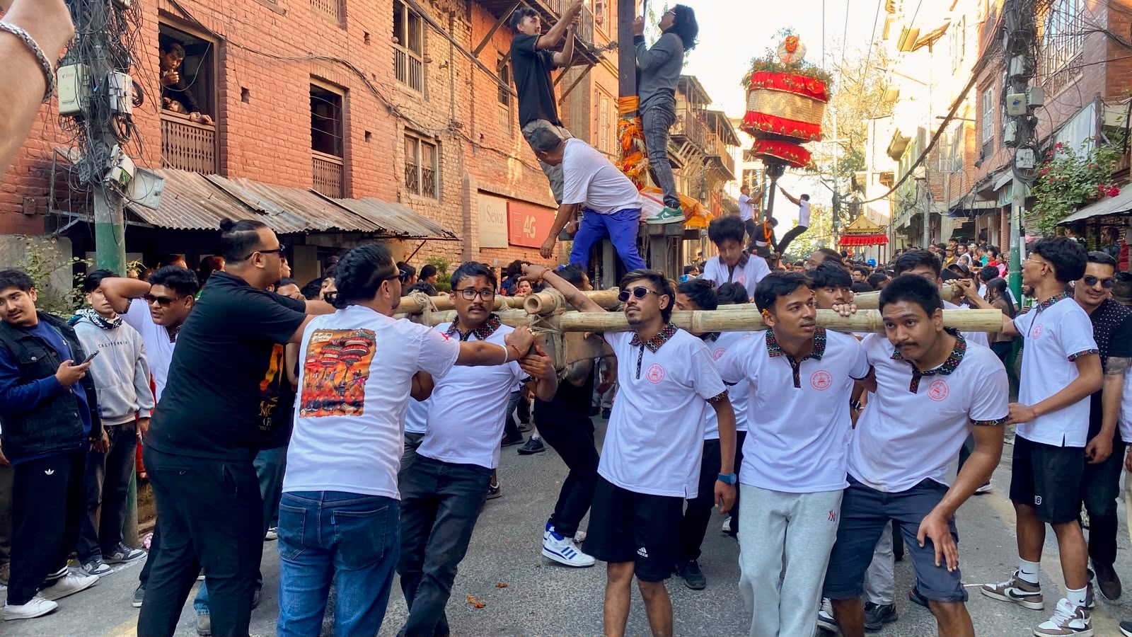 Young men carry the khat on bamboo poles during Hadigaun Jatra